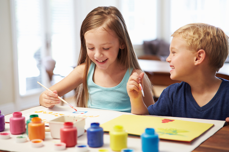 Two Children Painting Picture At Home